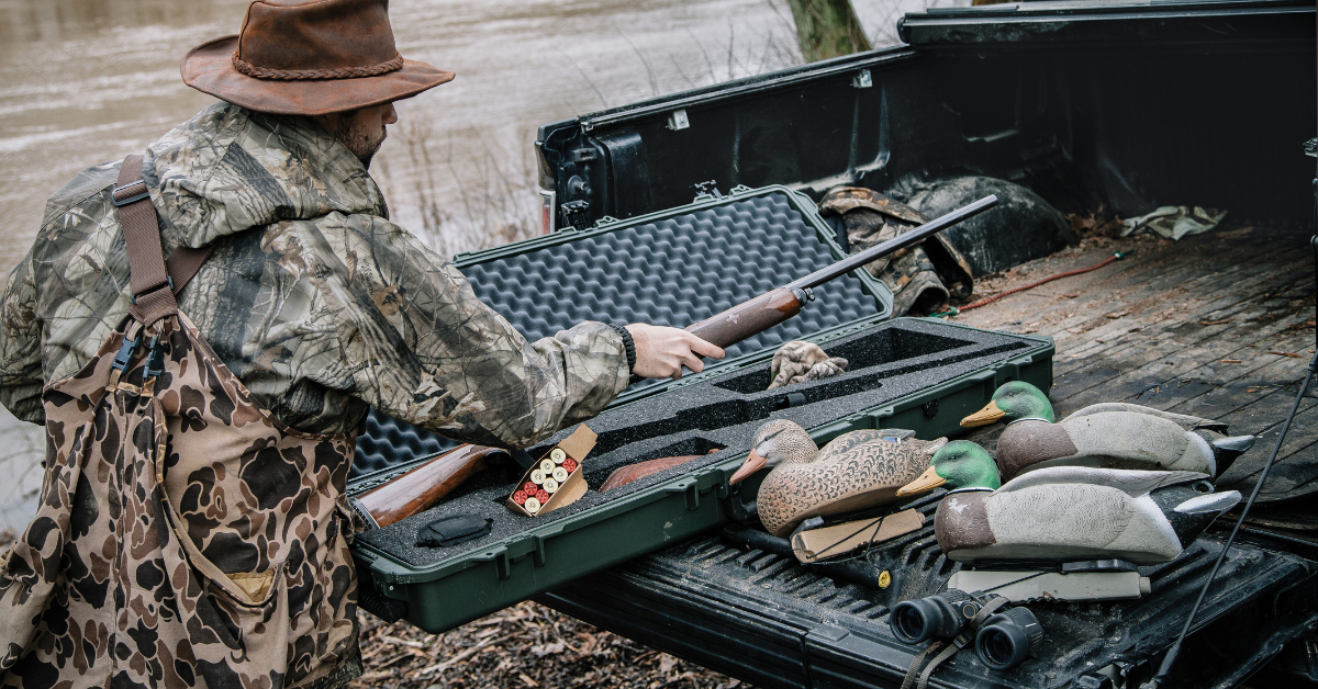 Professional tactical hunting gear setup with protective cases and military-grade equipment in outdoor environment
